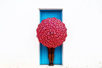 Close-up of red door against white background