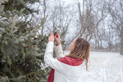 Full length of child standing on snow covered tree