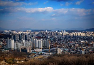 Cityscape against cloudy sky