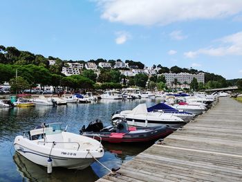 Boats moored in harbor against buildings in city