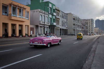 Vintage car moving on road in city