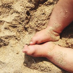 Close-up of human feet on beach