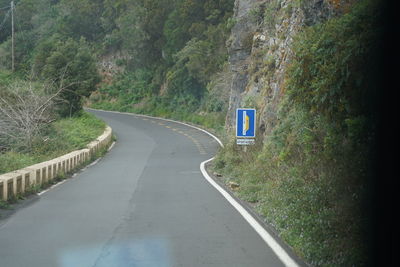 Empty road amidst trees in forest