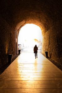 Rear view of man walking in tunnel