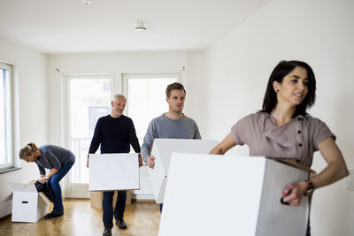 Family of four with cardboard boxes moving into new house