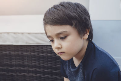 Close-up of cute boy looking away at home