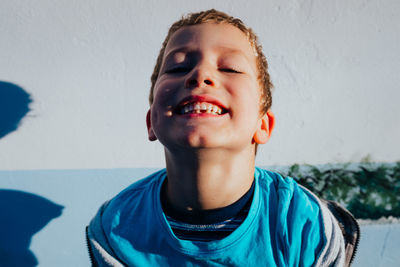 Portrait of smiling boy against wall