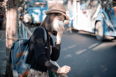 Woman wearing mask standing at road