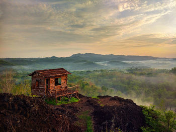 Built structure on landscape against sky during sunset