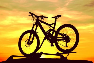Silhouette bicycle against sky during sunset