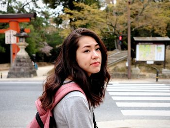 Portrait of beautiful young woman on road in city