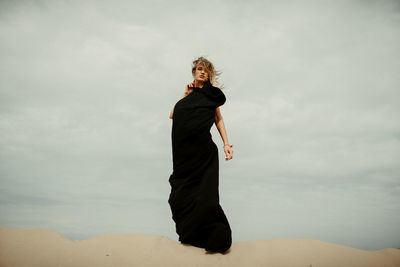 Full length of woman standing on land against sky