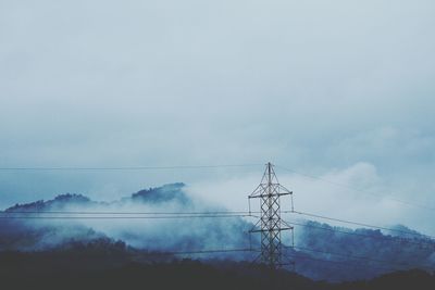 Low angle view of electricity pylon against sky