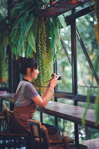 Side view of man photographing through smart phone