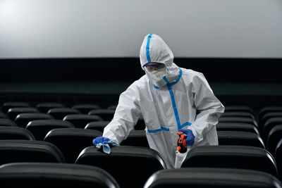 Man sanitizing seats in theatre