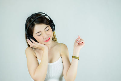 Young woman wearing mask against white background