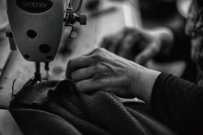 Cropped image of woman using sewing machine at home