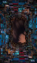 Directly below shot of buildings against sky at night