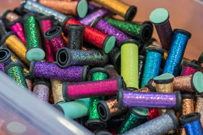 Rolls with metallic threads in plastic container in assortment for craft