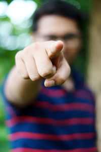 Young man pointing while standing outdoors