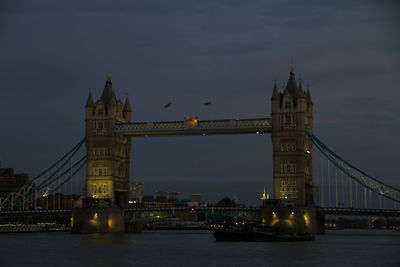 View of suspension bridge over river at night