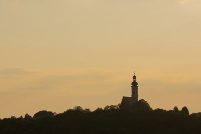 Silhouette lighthouse against sky during sunset