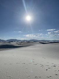 Scenic view of beach against bright sun