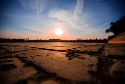 Surface level of land against sky during sunset