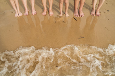 Low section of people standing on tiled floor