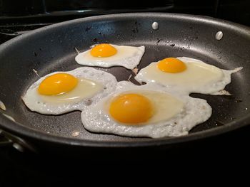 Close-up of fried eggs preparing in cooking pan