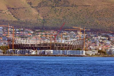 Scenic view of sea by town against sky during winter