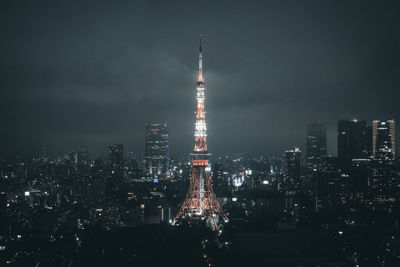 Illuminated buildings in city against sky at night