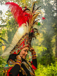 Rear view of woman standing in forest