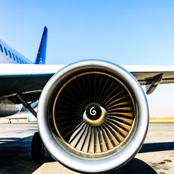 Airplane on airport runway against clear blue sky