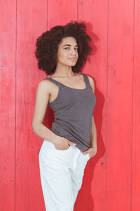 Portrait of woman standing against wooden wall