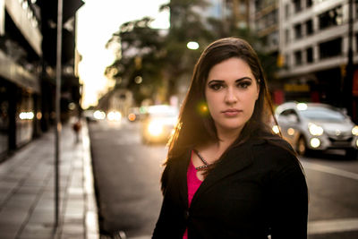 Young woman standing on illuminated city at night