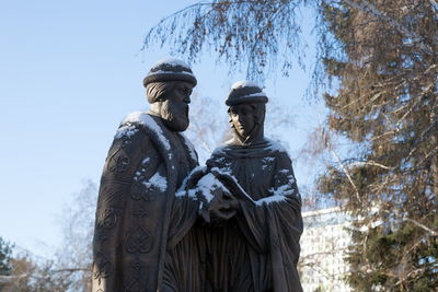 Monument to saints peter and fevronia as well as the symbols of love and fidelity against the trees.