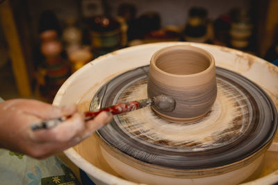 Cropped hands of potter making pot