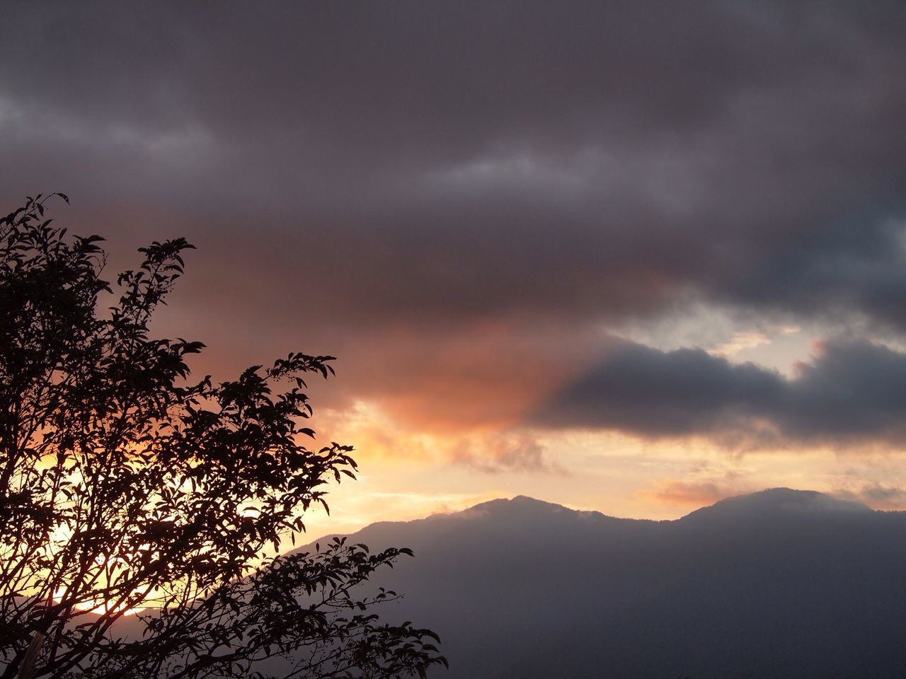 scenics, sunset, sky, tranquil scene, beauty in nature, tranquility, silhouette, mountain, cloud - sky, tree, nature, dramatic sky, cloudy, idyllic, mountain range, orange color, landscape, cloud, weather, majestic