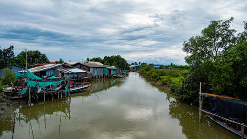 Panoramic view of river amidst trees and buildings against sky