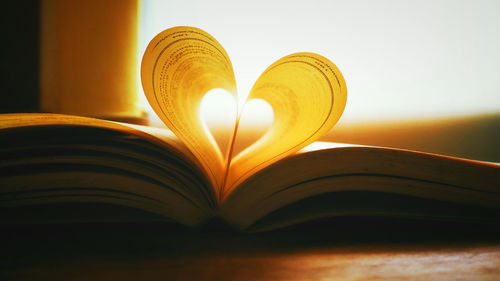 Close-up of heart shape pages in book on table at home