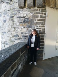 Full length of woman standing against wall