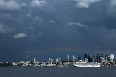 Sea by buildings against sky in city