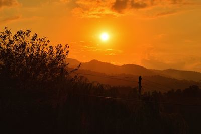 Scenic view of silhouette landscape against orange sky