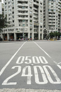 Road sign on street against buildings in city