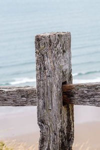 Close-up of wooden post against sea