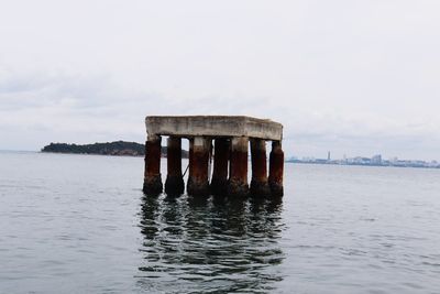 Built structure on pier over sea against sky
