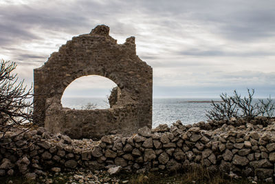 Stone wall against cloudy sky