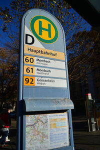 Close-up of road sign against trees in city