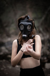 Portrait of woman wearing gas mask standing outdoors